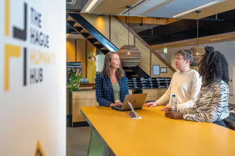 People behind a desk at The Hague Humanity Hub