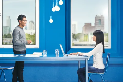 Couple in a blue room with a laptop