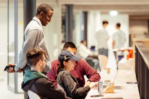 Group of young people behind a computer