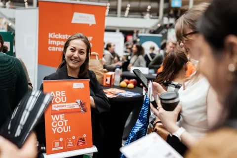Employee of Work in South Holland talking to students at a career fair