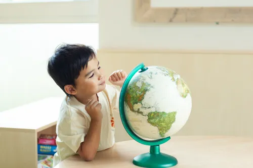 Child at childcare looking at a globe