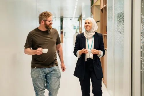 Woman and man walking, talking and having coffee